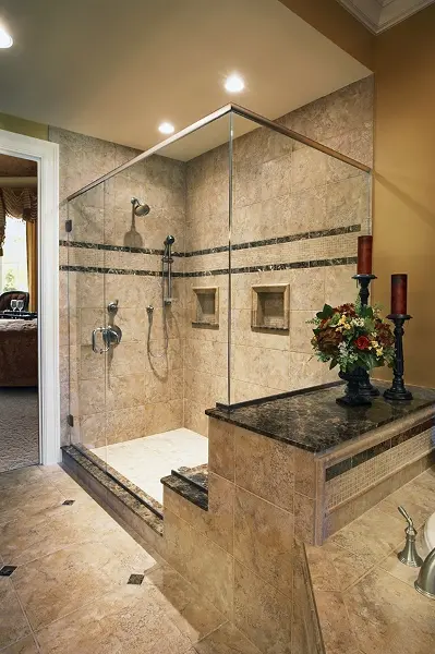 A small, luxurious bathroom with a stand up shower and brown